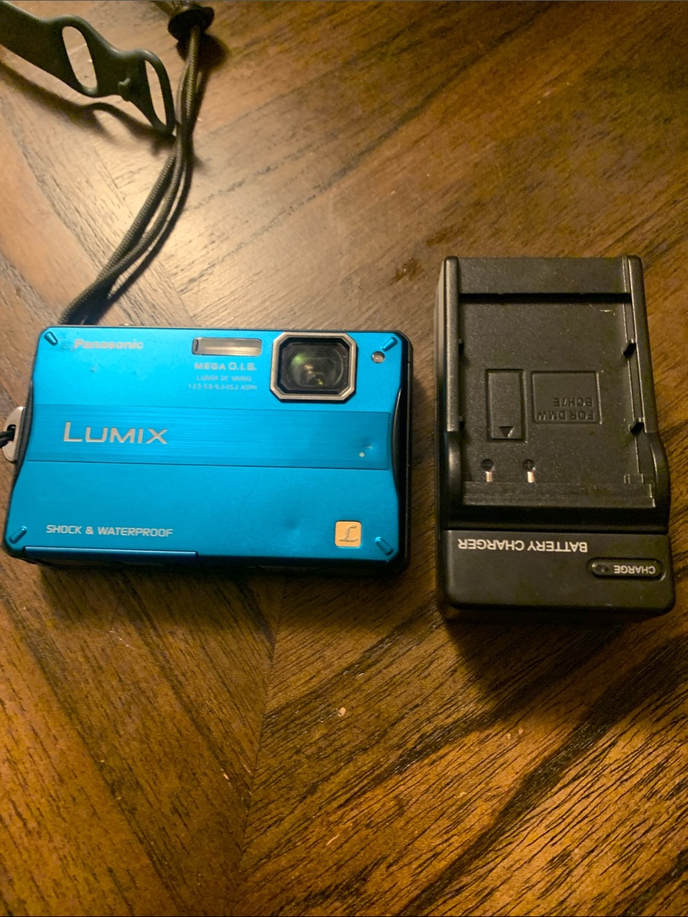 Panasonic Lumix compact camera in bright blue with black charger